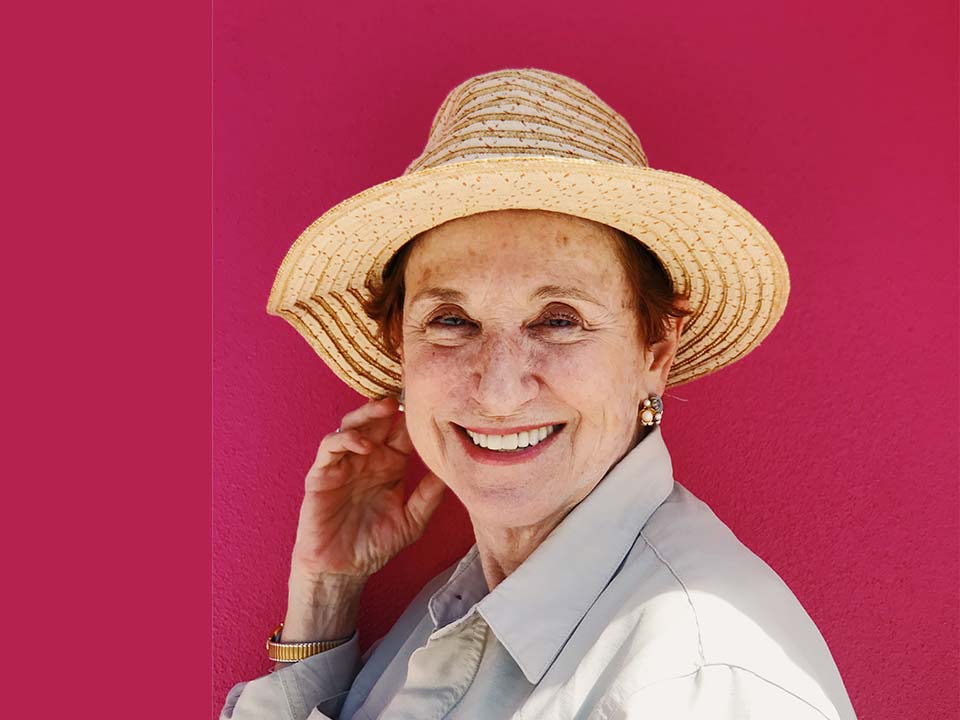 Old lady wearing a hat on a pink background
